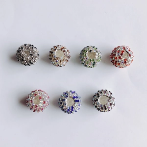Makroaufnahme von sieben glitzernden Pavé-Kristallperlen für DIY-Schmuck in verschiedenen Farben