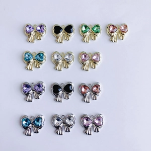 Macro detail of DIY jewelry bow pendants featuring heart-shaped zircon stones in multi colors