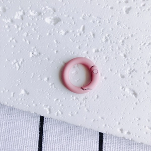 Detailed close-up of matte pink round spring buckle for DIY keychains and bag accessories