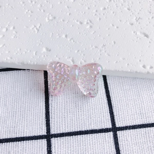 Macro detail of a translucent iridescent pink resin butterfly charm with glitter finish