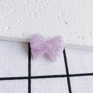 Dettaglio macro del fiocco in acrilico viola chiaro con trama di perline di zucchero brillanti