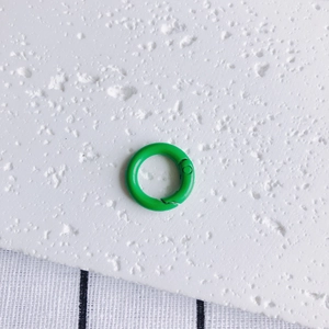 Macro detail of 20mm green metal spring ring buckle with painted finish for DIY crafts