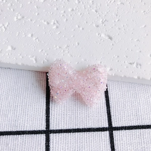 Dettaglio macro di un fiocco rosa iridescente con glitter per la creazione di gioielli DIY
