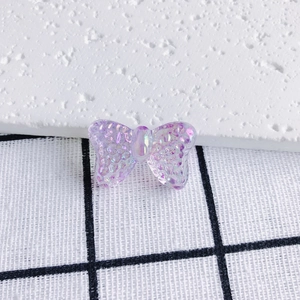 Macro shot of purple translucent glitter butterfly pendant with iridescent shell texture