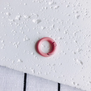 Detailed macro view of a pink 20mm round metal spring gate ring with a smooth finish