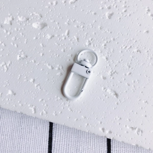 Détail macro d'un fermoir mousqueton en métal blanc pour bijoux DIY et porte-clés