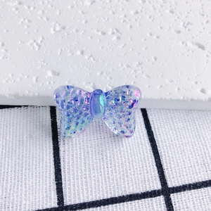 Macro detail of iridescent blue resin butterfly pendant with textured surface