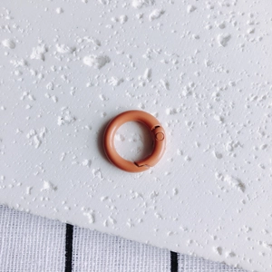 Detail of 20mm round metal spring snap hook with vibrant orange painted finish for DIY