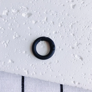 Close-up of black matte metal spring O-ring buckle for DIY keychains and bags