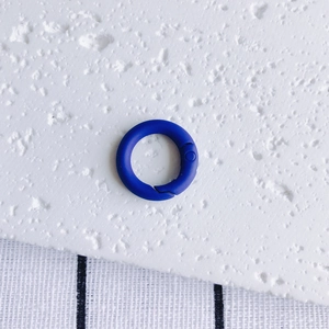 Close-up of a matte dark blue round spring gate ring clasp for DIY jewelry making