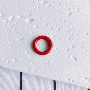 Detailed view of a bright red 20mm round metal spring ring for DIY crafts and keychains
