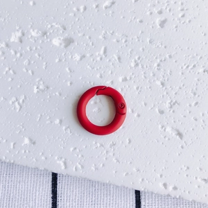Macro shot of a red round spring gate snap hook for DIY jewelry and bag hardware