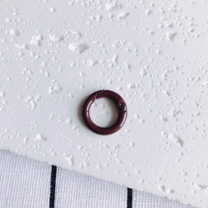 Detail of 20mm dark red spring gate ring with smooth finish for DIY accessories