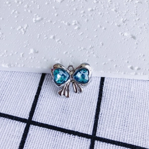Close-up of bow-shaped pendant with heart-shaped blue crystals and silver metal frame