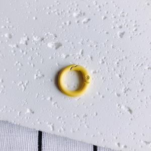 Close-up of bright yellow 20mm round spring ring buckle with smooth painted finish