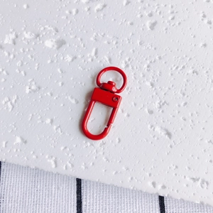 Détail d'un fermoir mousqueton en métal émaillé rouge pour porte-clés DIY