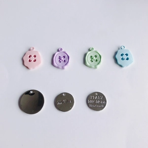 Close-up of candy-colored button charms and handmade metal alloy pendants for DIY jewelry