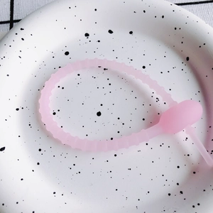 Detailansicht der rosa Silikon-Kabelbinder mit Perlenstruktur auf einem Dekoteller