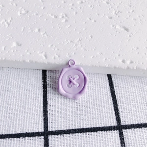 Macro shot of light purple enamel candy-colored button-shaped charm for DIY jewelry making
