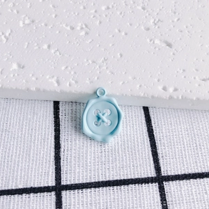 Close-up of light blue candy-colored button pendant charm for DIY jewelry making