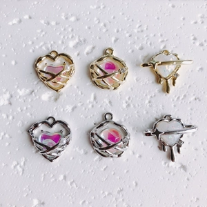 Close-up of molten heart and star pendants with iridescent stones in gold and silver plating