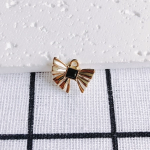 Detail eines goldenen Schleifenanhängers mit schwarzem Edelstein für DIY-Schmuckdesign