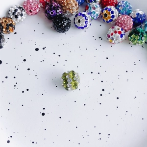 Macro shot of 10mm light green rhinestone clay beads for DIY jewelry making and crafts