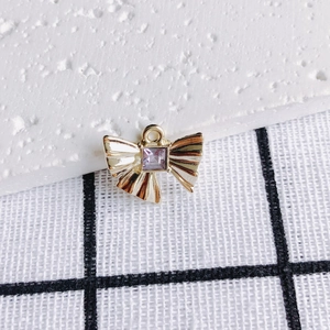 Makro-Detail von goldenem Schleifen-Anhänger mit violettem Zirkon für DIY-Schmuck