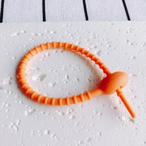 Detailansicht eines orangefarbenen Silikon-Kabelbinders mit verstellbarer Schlaufe