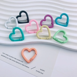 Dettaglio macro di nove anelli a molla colorati a forma di cuore per portachiavi fai da te