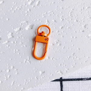 Détail d'un mousqueton en métal orange mat pour la fabrication de porte-clés et bijoux
