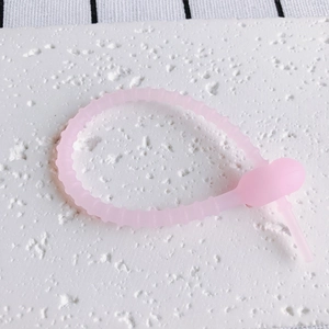 Detailansicht des flexiblen rosa Silikon-Kabelbinders mit rutschfester Rillenstruktur