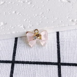 Detail eines rosa Schleifenanhängers mit Zirkonia-Inlay und vergoldetem Rand für DIY