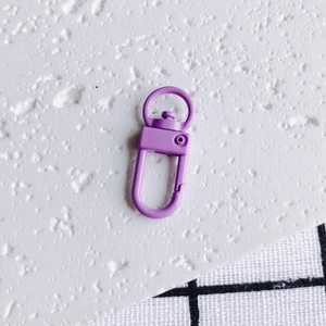 Gros plan sur un fermoir mousqueton en métal violet peint pour la création de porte-clés