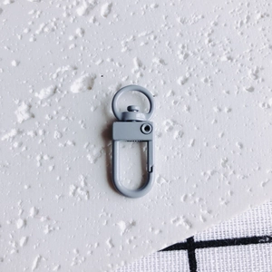Gros plan du fermoir mousqueton en métal bleu-gris mat avec anneau rotatif pour DIY