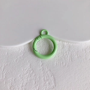 Detailopname van een lichtgroene ronde veerring met klein oogje voor DIY-sieraden