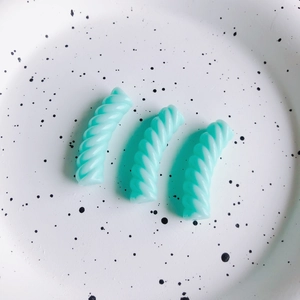 Dettaglio macro di perline a spirale in resina verde menta per set di gioielli fai da te