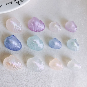 Detailed view of iridescent shell-shaped charms in various sizes and mermaid colors