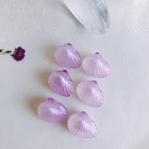 Close-up of iridescent purple fan shell beads with a pearlescent finish for DIY jewelry
