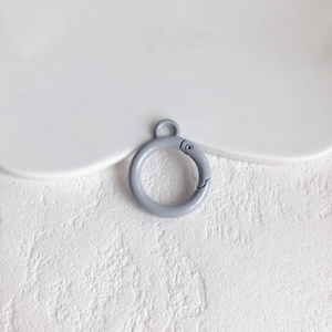 Detail van een mat grijs-blauwe ronde veerring voor DIY sleutelhangers en tasaccessoires