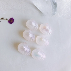 Macro detail of iridescent mermaid fan shell charms with pearl luster for DIY jewelry making