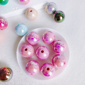 Close-up of 16mm iridescent acrylic beads in pastel pink and blue for DIY jewelry making