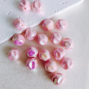 Macro view of 16mm pink iridescent acrylic beads with pearl finish for DIY jewelry crafts
