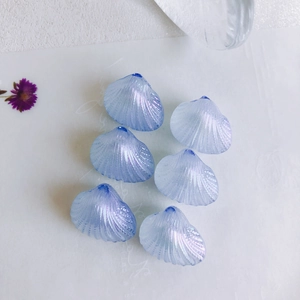 Macro view of six iridescent light blue shell beads for DIY jewelry making and crafts