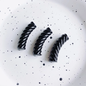 Dettaglio di perline a spirale in resina nera per creazione gioielli fai-da-te