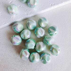 Macro detail of irregular mint green iridescent acrylic beads for DIY jewelry making