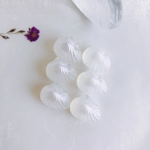Detailed view of iridescent mermaid shell charms for DIY jewelry making and necklaces