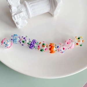Macro shot of colorful hand-painted acrylic beads with hearts and dots for DIY jewelry