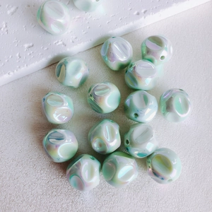 Close-up of 16mm mint green iridescent acrylic beads for DIY jewelry making