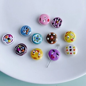 Macro shot of colorful hand-painted acrylic beads with cartoon faces for DIY jewelry making